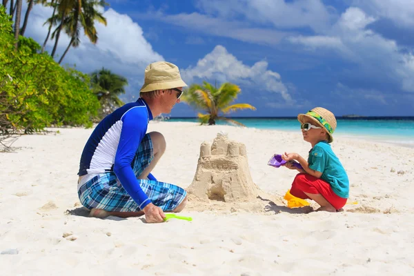 Padre e hijo construyendo castillo de arena en la playa — Foto de Stock