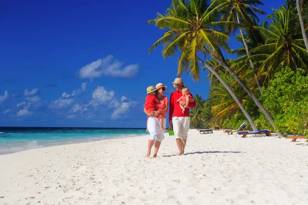 Giovane famiglia con due bambini che camminano in spiaggia — Foto Stock