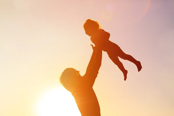 Vater und kleine Tochter spielen bei Sonnenuntergang — Stockfoto