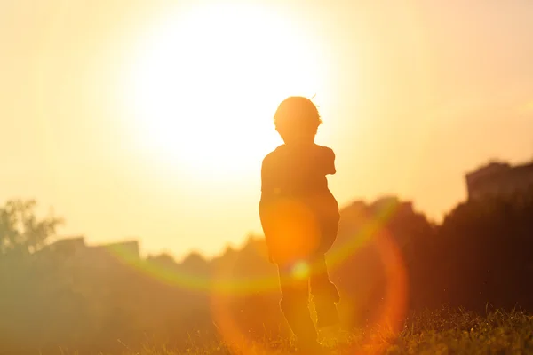 Silhuett av liten pojke kör vid solnedgången — Stockfoto