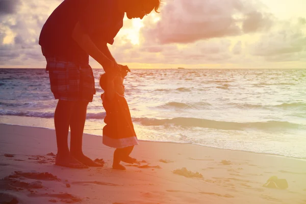 Silueta otce a malá dcerka procházky při západu slunce — Stock fotografie