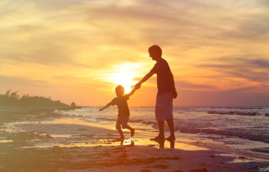 Baba ve oğul günbatımında eğleniyor