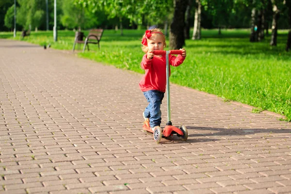 Gadis kecil yang lucu naik skuter di taman musim panas — Stok Foto