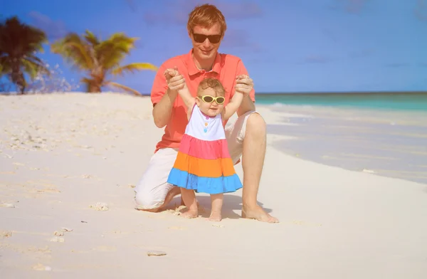 Isä ja pieni tytär leikkivät rannalla — kuvapankkivalokuva