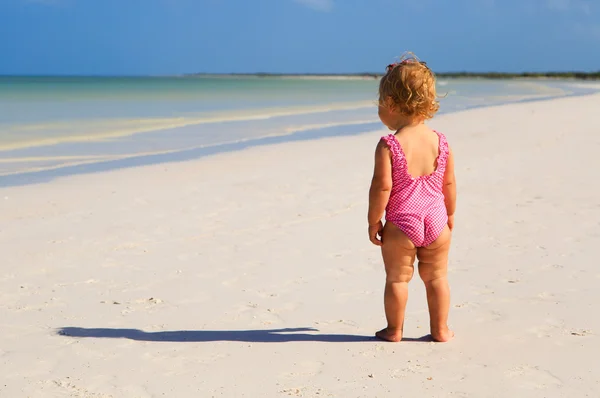 Маленькая девочка смотрит на тропический пляж — стоковое фото