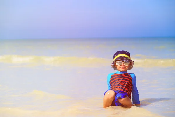 Kleine jongen spelen met water op strand — Stockfoto