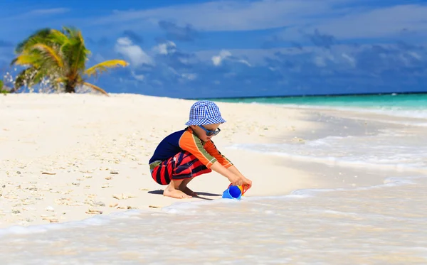 Bambino che gioca con l'acqua sulla spiaggia — Foto Stock