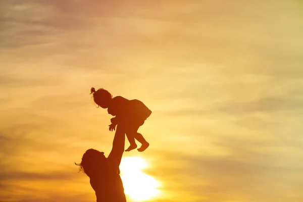 Батько і маленька дочка силуети на заході сонця — стокове фото
