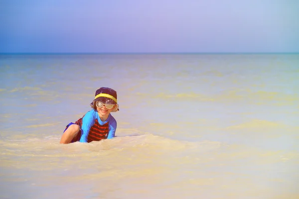 Petit garçon jouant avec l'eau sur la plage — Photo