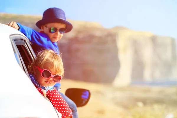 Happy little boy and girl travel by car in mountains — Stock Photo, Image