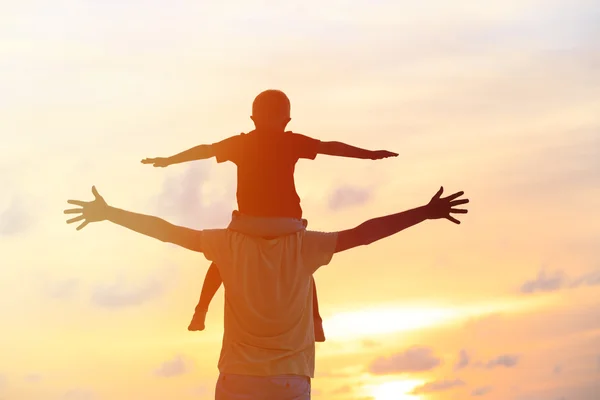 Батько і син грають на небі заходу сонця — стокове фото