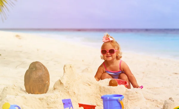 Sevimli küçük kız sahilde kum ile oynamak — Stok fotoğraf