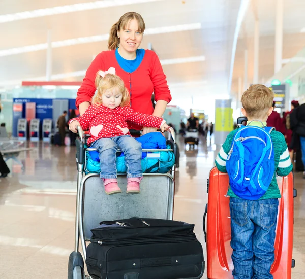 Семья с двумя детьми путешествует в аэропорту — стоковое фото