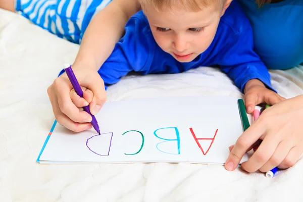 Handen van moeder en kind schrijven van brieven — Stockfoto