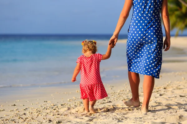 Mère et petite fille marchant sur la plage — Photo