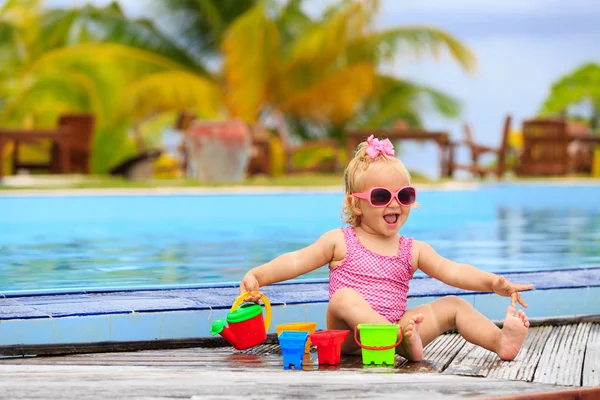 Roztomilá holčička hraje v bazénu na pláži — Stock fotografie