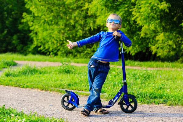 Felice ragazzino godere di equitazione scooter in estate — Foto Stock