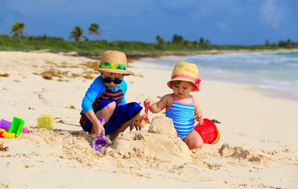 Barn som leker med sand på sommaren beach — Stockfoto