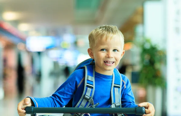 Felice bambino carino in aeroporto cavalcando sul carrello bagagli — Foto Stock