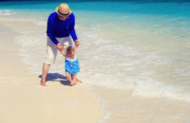 Baba ve küçük kız Sahilde yürüyüş