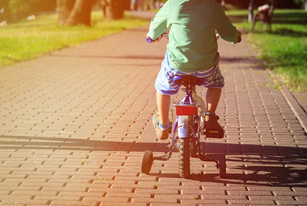 Bambino in sella alla bici nel parco estivo — Foto Stock