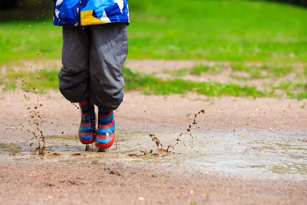 Niño jugando en charco fangoso — Foto de Stock