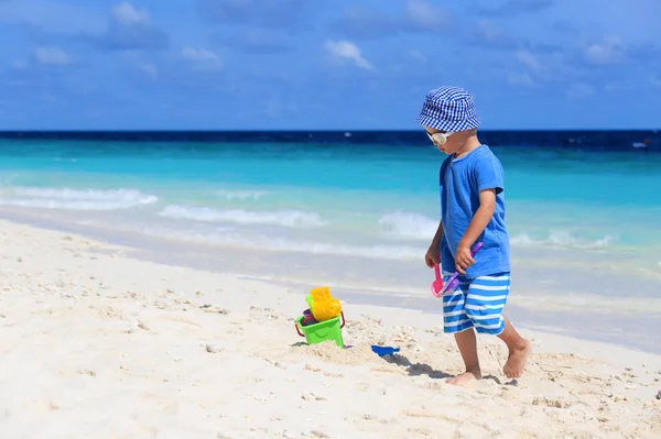 Kleiner Junge spielt mit Sand am Strand — Stockfoto