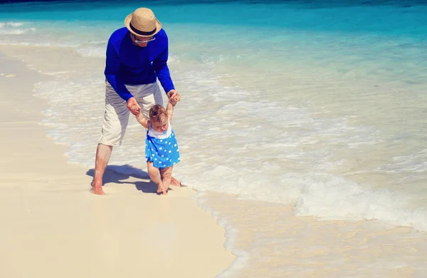 Vader en dochtertje wandelen op het strand — Stockfoto