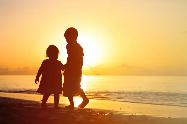 Kleine Jungen und Mädchen Händchen haltend bei Sonnenuntergang — Stockfoto