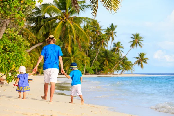 Padre y dos niños caminando en la playa tropical —  Fotos de Stock