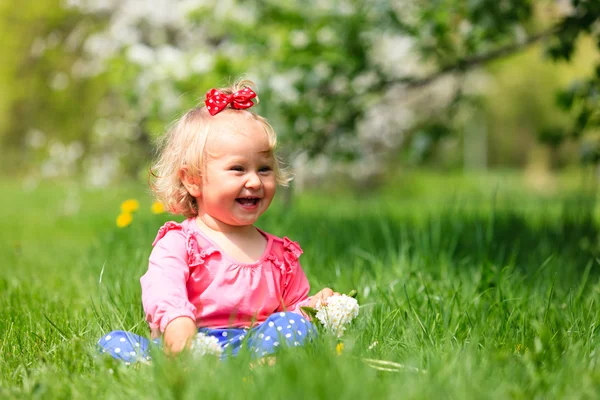 Gadis kecil yang bahagia dengan bunga di musim semi — Stok Foto