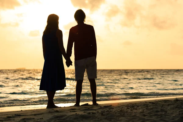 Ρομαντικό ζευγάρι, κρατώντας τα χέρια στο ηλιοβασίλεμα — Φωτογραφία Αρχείου