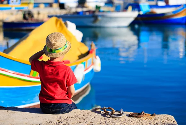 Menino olhando para barcos tradicionais em Malta — Fotografia de Stock