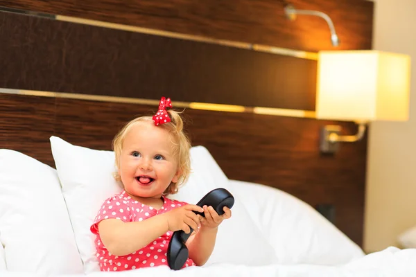 Söt liten flicka med i telefon i hotellrum — Stockfoto