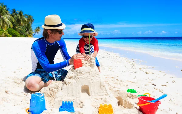 Padre e hijo construyendo castillo de arena en la playa — Foto de Stock