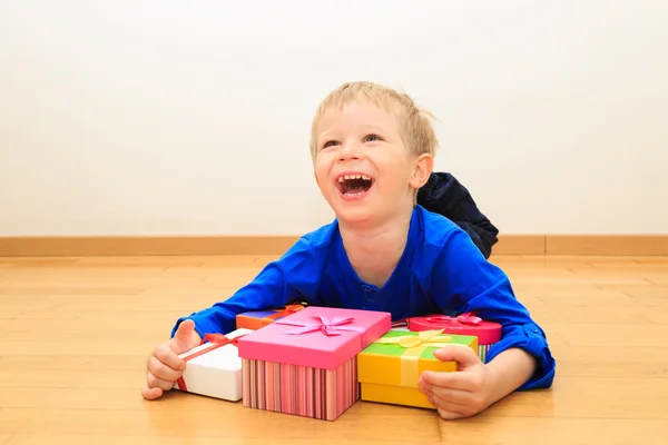 Niño pequeño tomando regalos en vacaciones en familia — Foto de Stock