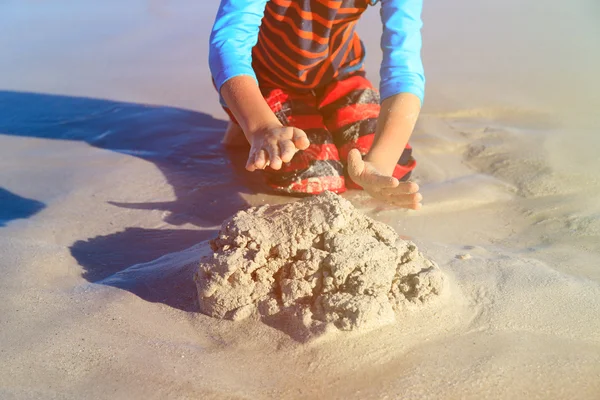 Menino brincar com areia na praia — Fotografia de Stock