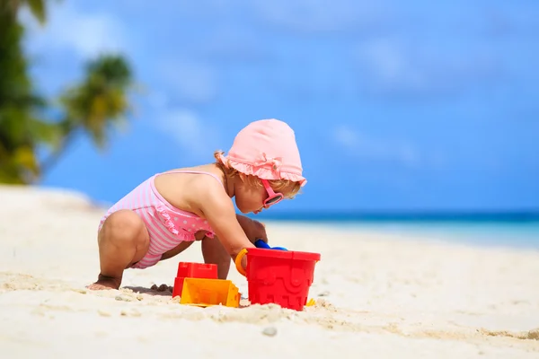 Søt, liten jente som leker med sand på stranda – stockfoto