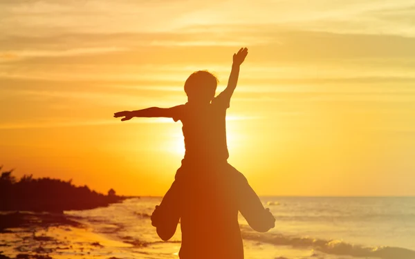Pai e pequeno filho se divertindo ao pôr do sol — Fotografia de Stock