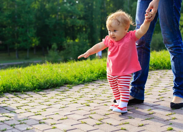 Första steg av liten flicka i sommaren park — Stockfoto
