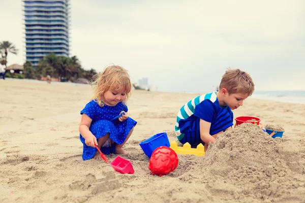 Niños juegan con arena en la playa de verano — Foto de Stock