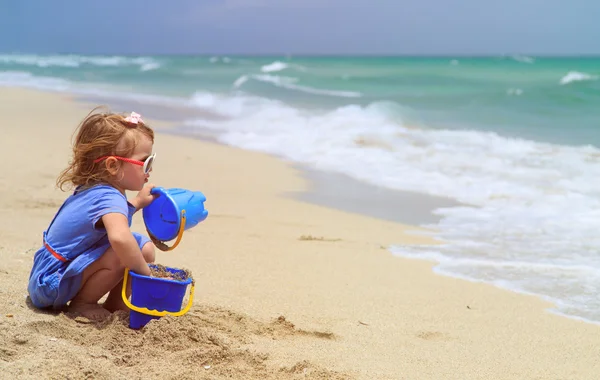 해변에서 모래가 놀고 어린 소녀 — 스톡 사진
