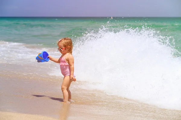 Cute little girl play with water on beach — Stock Photo, Image