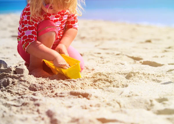Маленькая девочка играет с игрушками на пляже — стоковое фото