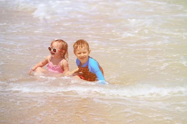 Ευτυχής παιδιά παίζουν με τα κύματα στην παραλία — Φωτογραφία Αρχείου