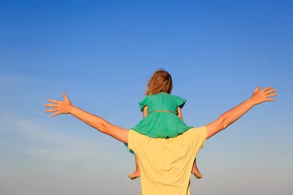 Батько і маленька дочка на плечах грають на небі — стокове фото