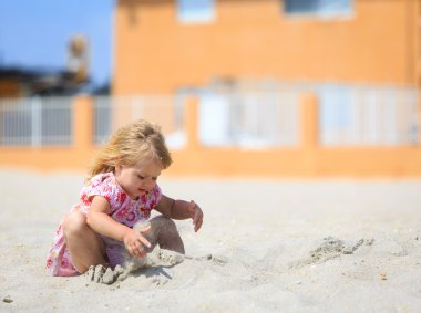 küçük kız sahilde kum ile oynamak