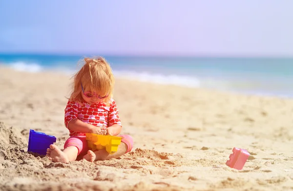 Malá holčička hrát s hračkami na pláži — Stock fotografie