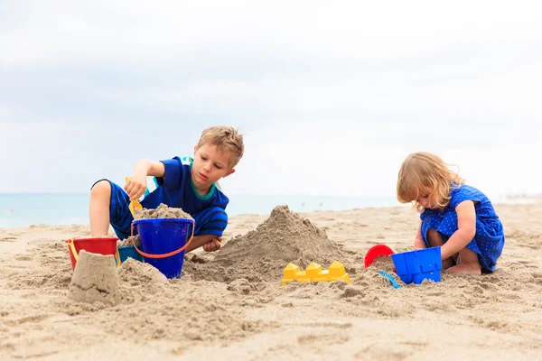 Діти грають з піском на літньому пляжі — стокове фото