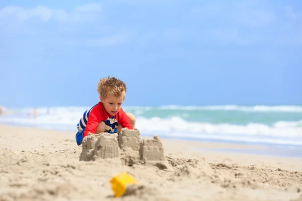 Kleine jongen spelen met zand op zomerstrand — Stockfoto